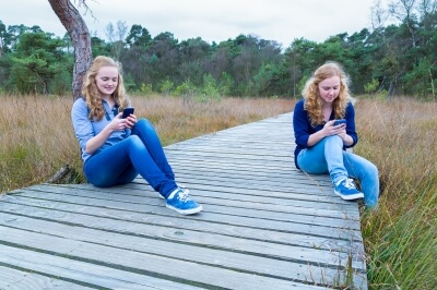 Two girls using social media in nature